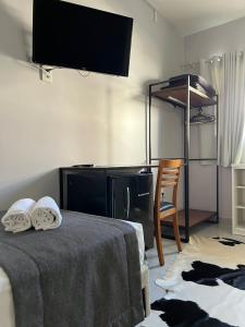 a bedroom with a tv and a bed with a chair at Pousada CasaPark in Penha +52 photos