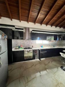 een keuken met zwarte kasten en een fornuis met oven bij Hermoso penthouse dosquebradas in Dosquebradas