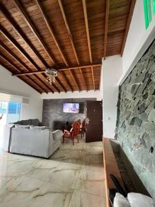 een woonkamer met een bank en een stenen muur bij Hermoso penthouse dosquebradas in Dosquebradas