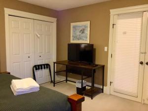 ein Schlafzimmer mit einem Bett und einem Schreibtisch mit Fernseher in der Unterkunft NeckPoint Treasure BNB in Nanaimo