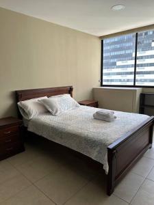 1 dormitorio con cama y ventana grande en Departamento en Puerto Santa Ana, en Guayaquil