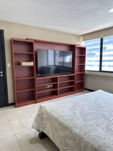 un gran centro de entretenimiento con TV en un dormitorio en Departamento en Puerto Santa Ana, en Guayaquil