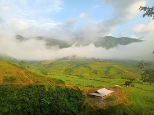 a misty valley with a house on a hill at Blue home in Mù Cang Chải