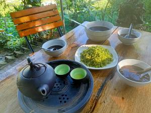 una mesa con tazones de arroz y una olla en ella en Blue home, en Mù Cang Chải
