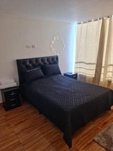 ein Schlafzimmer mit einem schwarzen Bett und einer Uhr an der Wand in der Unterkunft Apartamento 201 Riosucio in Ruiosucio