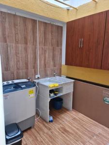eine Küche mit einer Theke, einer Spüle und Holzschränken in der Unterkunft Apartamento 201 Riosucio in Ruiosucio