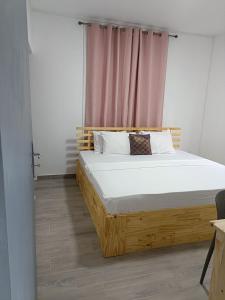 a bedroom with a wooden bed in front of a window at Cozy Lodge in Grand Gaube