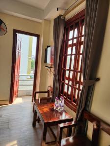 Thanh Hóaにあるkhách sạn Hoàng An - biển Hải Tiếnのリビングルーム(木製テーブル、窓付)
