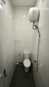 a white bathroom with a toilet and a shower at House of Bedjo in Demangan