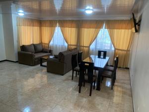 een woonkamer met een bank en een tafel en stoelen bij El Tambor B1 in Alajuela
