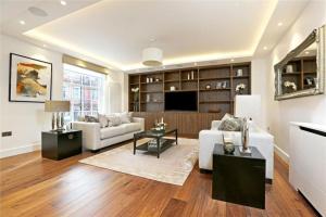 sala de estar con sofá y TV en Large Super Penthouse Park Lane Opposite Hyde Park Sleeps 12, en Londres