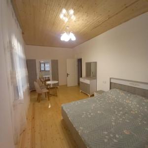 a bedroom with a bed and a table and a desk at Lahij Rashad Ismayilov Hotel in Lahıc