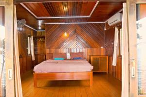a bedroom with a bed in a wooden boat at Maratua Guesthouse in Maratua Atoll