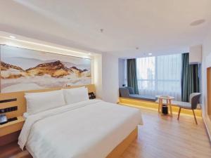 a hotel room with a bed and a chair and a window at Connar Hotel - Shenzhen Shawei in Shenzhen