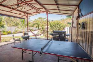 una mesa de ping pong en un patio con parrilla en Full house with 2 bedrooms and private pool, 5 guest, en Tarcoles