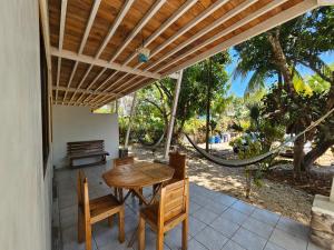 a patio with a wooden table and chairs on a porch at Don Jon's Surf and Yoga Lodge in Santa Teresa Beach