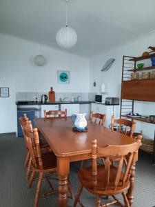 a kitchen with a wooden table and chairs at Purple Hen Country Lodge in Katikati