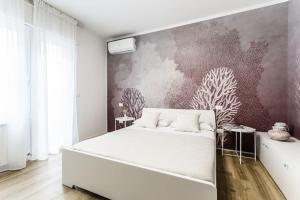 una camera con un letto bianco e un murale di La Bella Vita - La Terrazza a Sottomarina