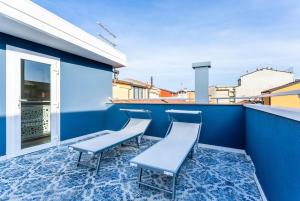 a balcony with chairs and a blue wall at La Bella Vita - La Terrazza in Sottomarina