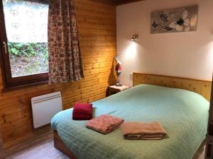 a bedroom with a bed with two towels on it at Chalet LE TREMPLIN, 4 à 5 pers, XONRUPT-LONGEMER in Xonrupt-Longemer