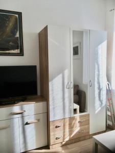 een woonkamer met een tv en een spiegel bij Apartments Ines - cozy studio in Zagreb