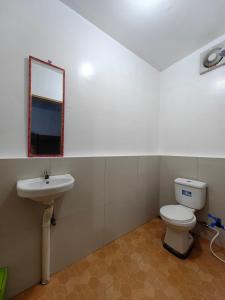 a bathroom with a toilet and a sink at DGA Traveler's Inn in Coron