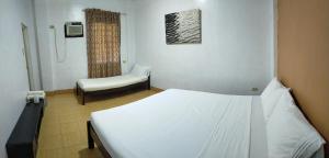 Habitación hospitalaria con cama y silla en Touristlink Homestay, en Donsol