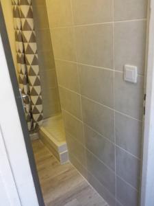 a bathroom with a shower with a bench at Studio Nîmes Centre in Nîmes