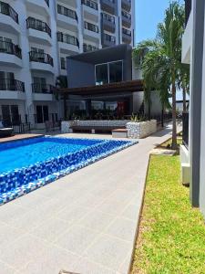 a swimming pool in front of a building at Mantra condominium in Ban Tha Fat