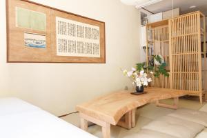 Una habitación con una mesa de madera con flores. en Saku House Jujo, en Tokio