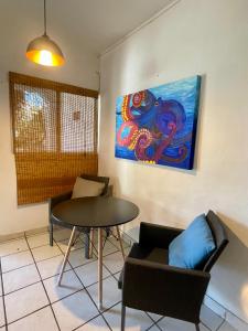 サン・ホセ・デル・カボにあるCasa Kanteのテーブルと椅子、絵画が備わる部屋