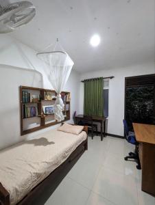 um quarto com uma cama, uma secretária e uma mesa em awana em Ambalangoda