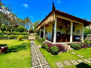 a house with a garden in front of it at Hotra Hill Cottage in Nusa Penida