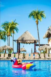 een zwembad met een speeltje in het water met palmbomen bij Margaritaville Beach Resort - Poolview - Costa Rica in Playa Flamingo