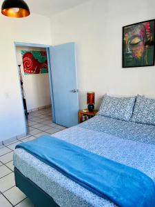 Un dormitorio con una cama con una manta azul. en Casa Kante en San José del Cabo