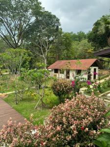 een huis met een tuin met bloemen ervoor bij Tamarind Villa in Kuah