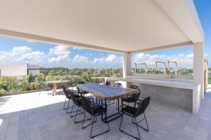 a patio with a table and chairs on a deck at Moderno estudio con fast wifi in Playa del Carmen