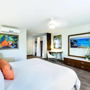 een slaapkamer met een groot wit bed en een bureau bij Margaritaville Beach Resort - Poolview - Costa Rica in Playa Flamingo
