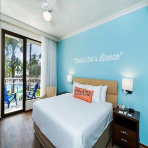 een slaapkamer met een bed met een blauwe muur bij Margaritaville Beach Resort - Poolview - Costa Rica in Playa Flamingo