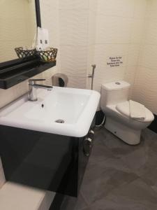 a bathroom with a white sink and a toilet at The Ardens Hotel - Nong Chik, Kolam Air, Johor Bahru in Johor Bahru