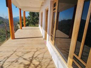 een houten veranda met uitzicht op de bergen bij Kumaon Lake's Home stay in Nainital