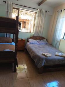 1 dormitorio con 2 camas y ventana en Oasis del Placer MOYDA en La Paz