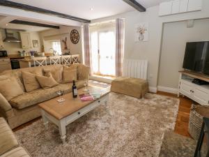 a living room with a couch and a coffee table at White Swan Cottage in Leyburn