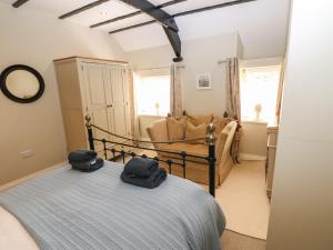 a bedroom with a bed and a couch at White Swan Cottage in Leyburn