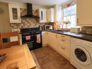 a kitchen with a stove and a dishwasher at Tizzie Whizie Cottage in Windermere