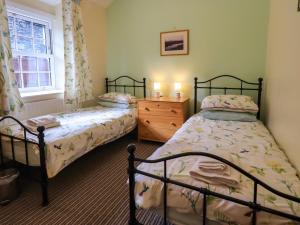 Кровать или кровати в номере Tizzie Whizie Cottage