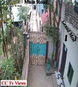 a gate to a house with a blue door at Grand Mess in Comilla