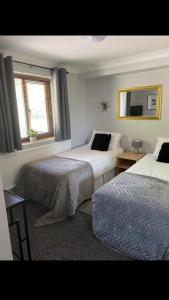 a hotel room with two beds and a window at Llanwenarth Hotel in Crickhowell