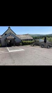 a building with two benches in a parking lot at Llanwenarth Hotel in Crickhowell