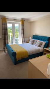 a bedroom with a blue bed and a window at Llanwenarth Hotel in Crickhowell